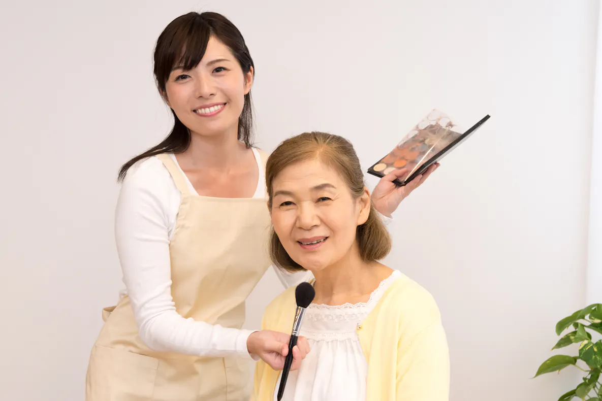 高齢女性にメイクをする訪問美容介護士.jpg