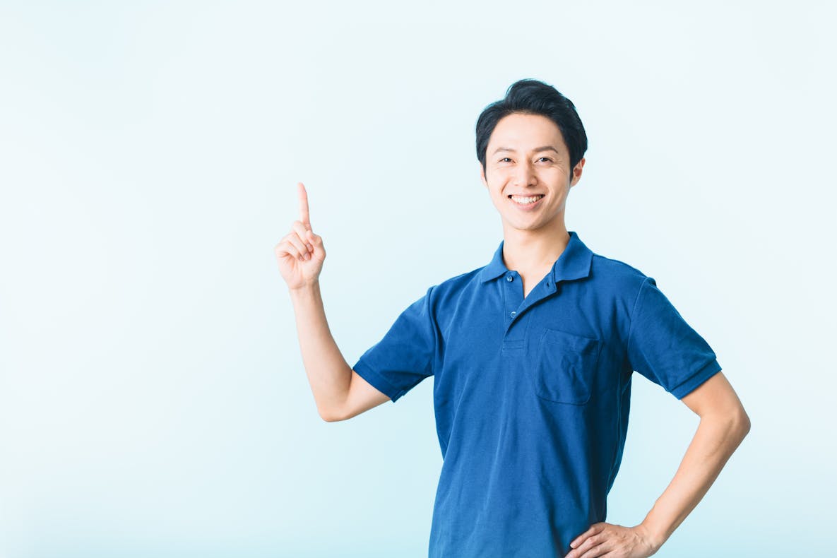 人差し指を立てる男性介護士