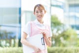ピンクエプロンを着たバインダーを持つ女性介護士